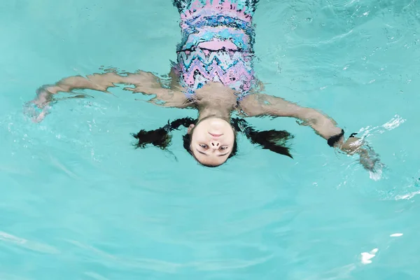 Meisje duik in het zwembad. Gelukkig meisje speelt in de poule. Mooi meisje zwemmen en plezier in het water. Actieve vakantie. — Stockfoto