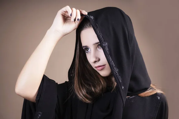 Arab ,muslim,girl closeup on a light background.Arab saudi emirates woman face looking at side on a light background.