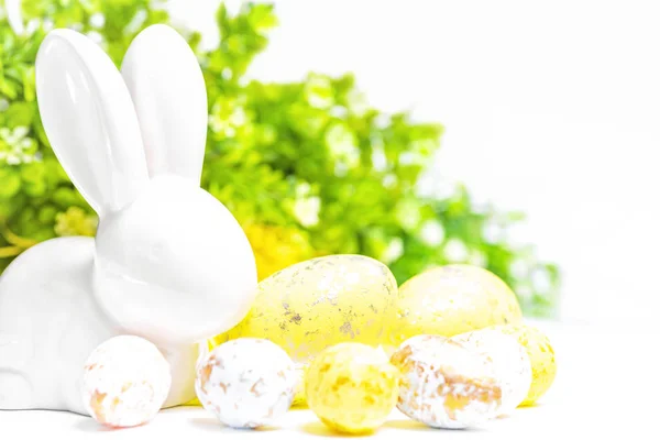 Happy Easter. Easter white bunny on a white background with Easter eggs.Easter greeting card with easter bunny.Postcard. Selective focus.Easter greeting card.Copy space.