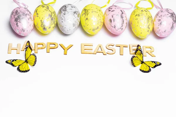 Huevos de Pascua multicolores sobre un fondo blanco con un montón de letras de madera Feliz Pascua. Feliz Pascua.Postal. Enfoques selectivos.Tarjeta de felicitación de Pascua.Copiar el espacio . —  Fotos de Stock