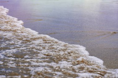 Kumlu plajda deniz yumuşak dalga. Kumlu plaj arka planda okyanus köpük ile yumuşak dalgalar