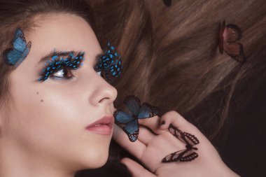 Saçında kelebekler olan güzel genç kız. Moda ve güzellik fotoğraf. Genç güzellik kadın Moda stüdyosu fotoğraf