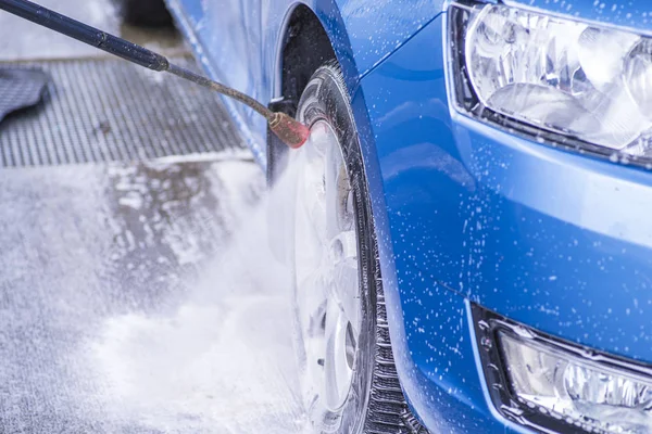 Ręczny Myjnia samochodowa z wodą pod ciśnieniem w myjni samochodowej na zewnątrz. Czyszczenie samochodu przy użyciu wody wysokociśnieniowej. — Zdjęcie stockowe