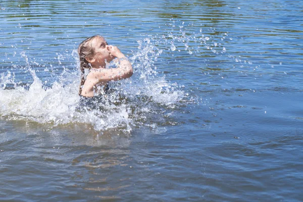 Little girl running through the water with a splash . in her hands cloth. — Stock Photo, Image