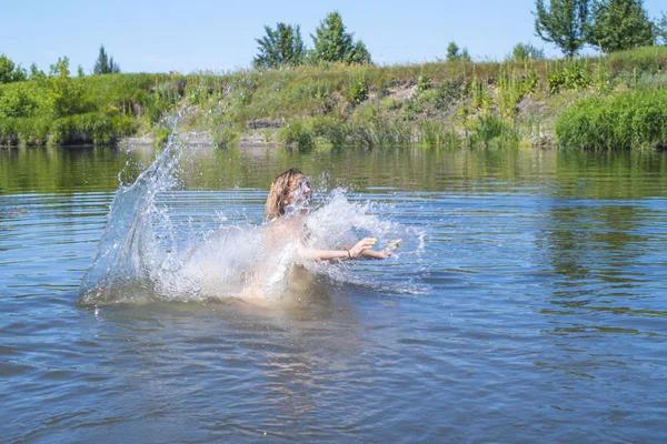 Woman jumps like fish into the water of the lake, swims, enjoys spending time on summer holidays.Woman jumps into the river.