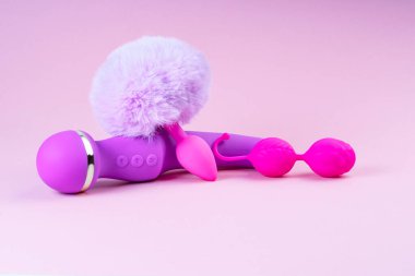 Collection of different types pink and violet of sex toys on pink background.Sex toys.Double vaginal balls and dildo vibrator and anal plug.