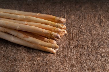 Kumaş arka planda çiğ organik beyaz kuşkonmazın yakın çekimi. Organik beyaz kuşkonmaz..