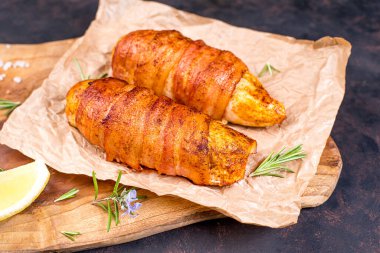 Et ve pastırma. Fırında fırında tavuk. Mağara kağıdında pastırmalı fırında tavuk rulosu ve limon ve biberiyeli mutfak tahtası..