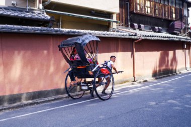 Japonya, Kyoto. 2018. Rickshaws Kyoto 'da popülerdir. Japonya, Kyoto. 2018. Japon faytonu bir kızı faytonla caddede gezdiriyor..