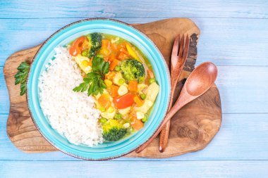Tavuk, sebze ve köri soslu beyaz pirinç. Sebzeli ve tavuklu Hint yemeği pilavı. Sehpada pilavlı körili tavuk..