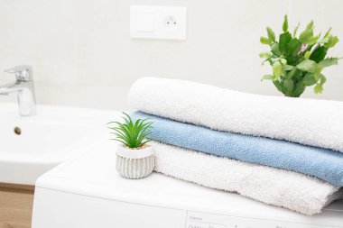 Modern çamaşır odasında havluyla çamaşır makinesi. Genç kız daireyi temizliyor. Temizlik yaptıktan sonra yorgun bir kız elinde elektrikli süpürgeyle yere oturur ve telefonda konuşur..