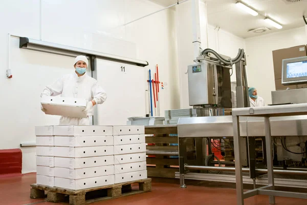 Ürün kutularında mal paketlemek. Gıda ürünü endüstrisi ve yüksek teknoloji üretim süreci için karton kutu paketleme.