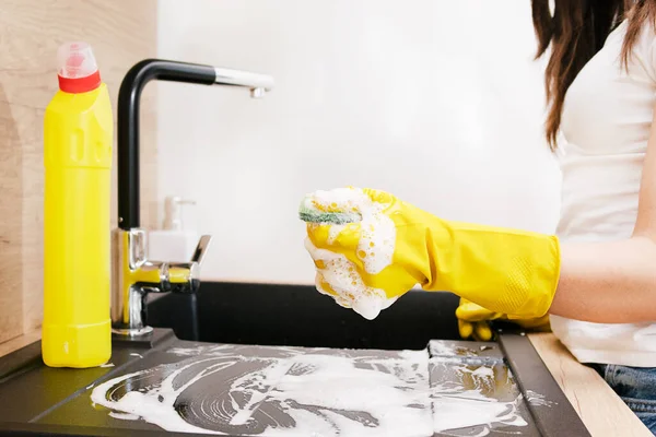Close-up of a woman cleaning a kitchen at home.Cleaning the kitchen in protective gloves.