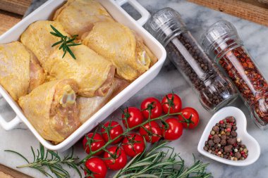 Fırında çiğ tavuk budu ve domates ve baharat..