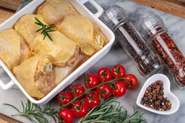 Fırında çiğ tavuk budu ve domates ve baharat..