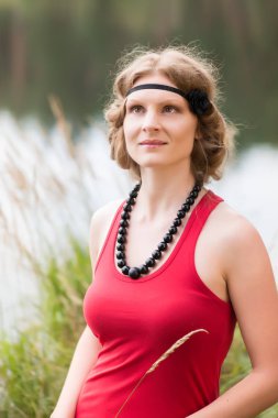 Yaz ortası sırasında lake yakınındaki ormanda genç kadın: Ligo Letonya