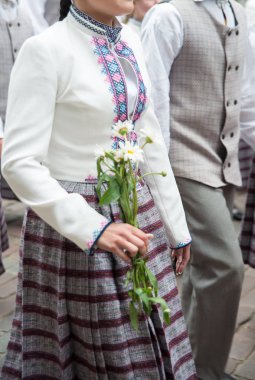 Ulusal Letonca öğeleri ve takım elbise, açılış Ulusal Letonca şarkı ve dans festivali Riga'da üzerinde alan çiçek demetleri grubu