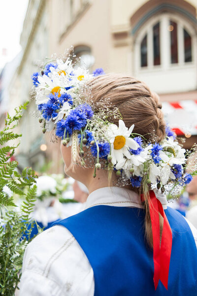 National latvian elements and suits, people with bouquets of field flowers on the openning of National Latvian Song and Dance Festival in Riga