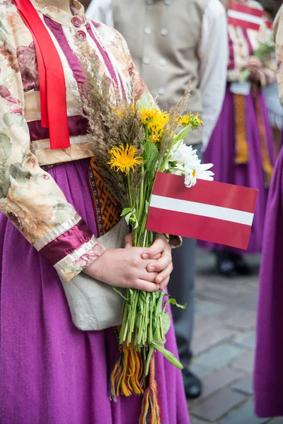 拉脱维亚民族的元素和西装 人们用鲜花花束在里加国家拉脱维亚歌舞节开幕式上 — 图库照片