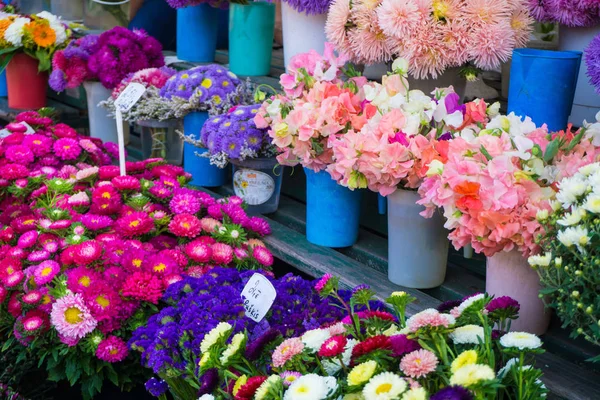 Different autumn flowers on sale on central market in bouquets with prices