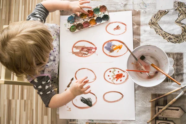 小女孩画和装饰复活节彩蛋与水的颜色 — 图库照片