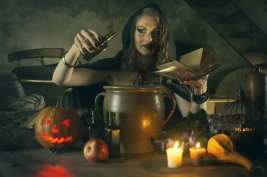 Siyah mantolu güzel cadı balkabağı ve sihirli şeyle