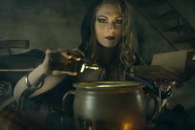 Siyah mantolu güzel cadı balkabağı ve sihirli şeyle