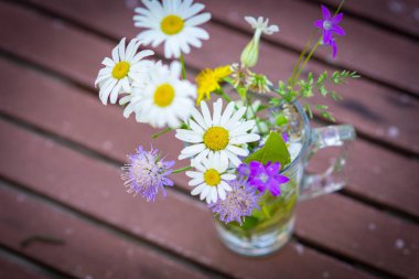 Güneşli bir Eylül gününde doğada bir buket yabani çiçekli tebrik kartı.