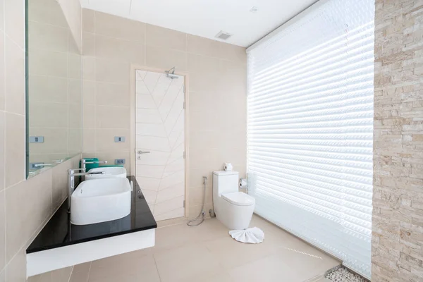 Роскошный красивый интерьер реальной ванной комнаты с раковиной, унитазом в доме или доме — стоковое фото