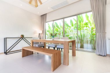 Havuz Villaları oturma odasında lüks iç tasarım. Yemek masası ile yüksek yükseltilmiş tavana sahip havadar ve aydınlık alan