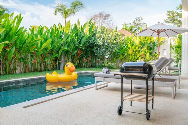 Casa o casa de diseño exterior que muestra villa piscina tropical con jardín verde, tumbonas y pato flotante — Foto de Stock