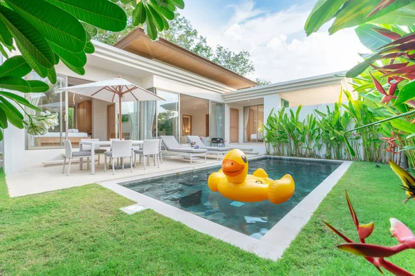 Haus oder Haus Außengestaltung mit tropischem Pool Villa mit grünem Garten, Sonnenliege und schwimmende Ente — Stockfoto
