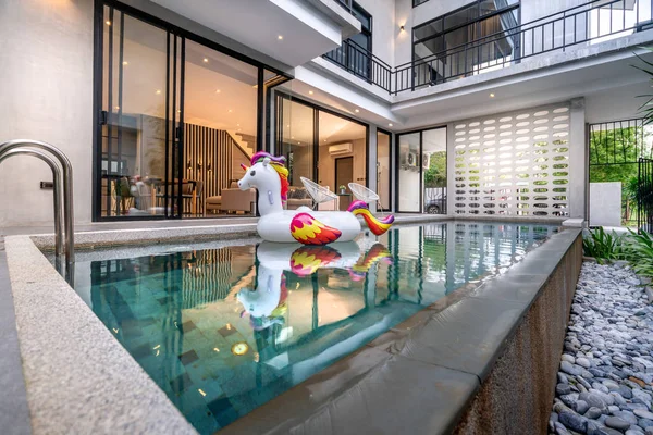 Buiten huis met zwembad en drijvende Eenhoorn in het huis — Stockfoto