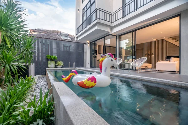 Buiten huis met zwembad en drijvende Eenhoorn in het huis — Stockfoto