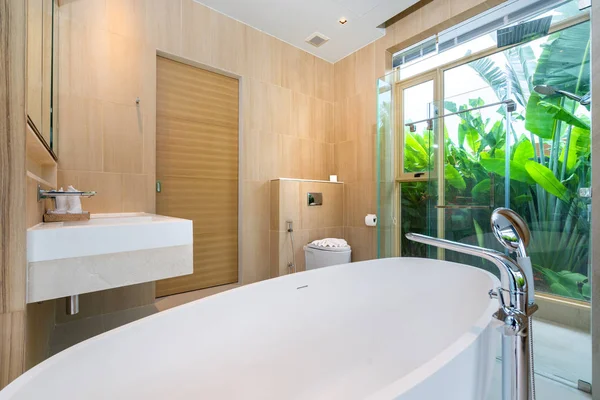 Роскошная ванная комната с ванной и зеленым садом — стоковое фото