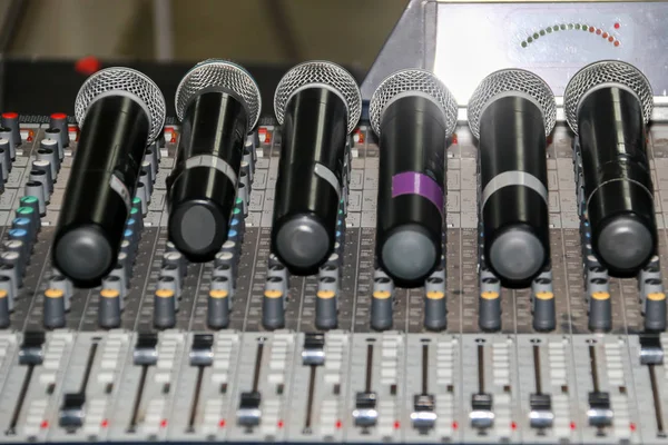 Menutup mikrofon nirkabel dan headphone memakai panel kontrol mixer musik. Panel Penyamakan Mixer Suara Stok Foto Bebas Royalti