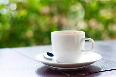 kahve fincanı kaşık ve doğal zemin üzerine ahşap masa üzerinde uçan daire ile