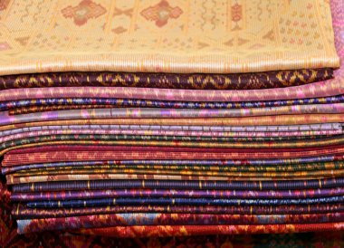Geleneksel renkli ipek, sarong yığını ve dokuma giysiler