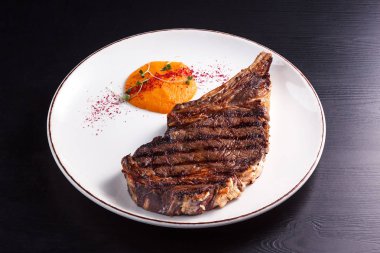 lezzetli ızgara biftek closeup görünümünü soslu beyaz plaka üzerinde 