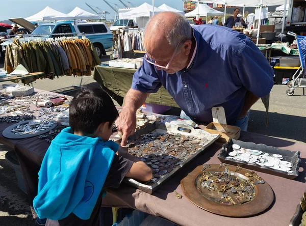 Flea market. Seller and boy with coin charms. — Stock Photo, Image