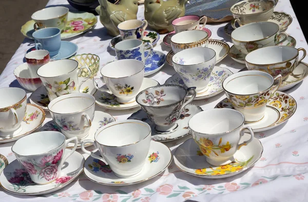 Vintage porcelain tea cups with saucers at flea market. — Stock Photo, Image
