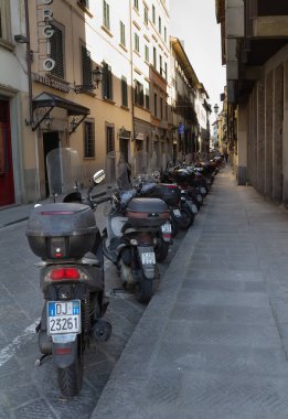 Scooter Floransa, İtalya'da bir yan sokak boyunca dizilmiş.