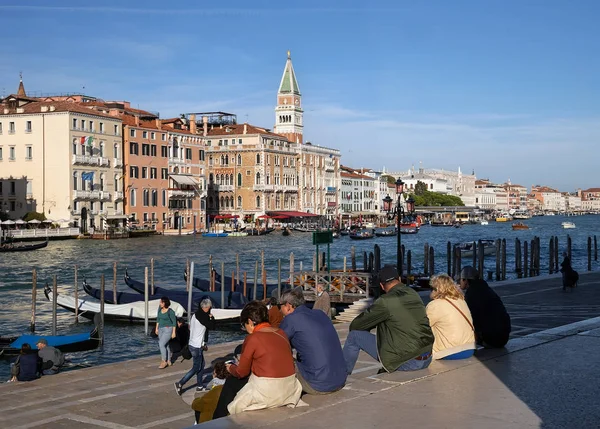 Toeristen zitten op de trappen en kijken naar het Grand Canal in — Stockfoto