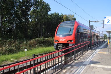 Kırmızı ve siyah R-Net hafif raylı tren araç Alphen ve Gouda arasında satır Boskoop tren istasyonunda
