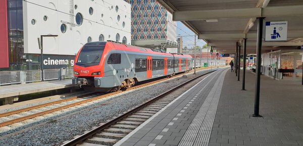 Red and black train on station Gouda a light rail train between alphen and gouda in the Netherlands