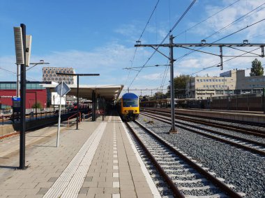 Çift katlı şehir içi tren istasyonu Gouda Hollanda platform boyunca bekliyor.