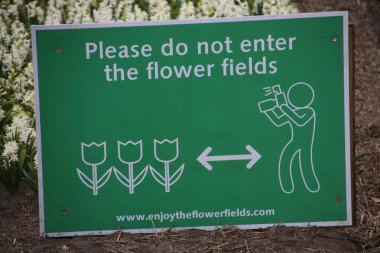 turistler fotoğraf için alanları girmemeyi uyarmaya Noordwijkerhout çiçek alanları üzerinde oturum 