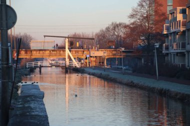 Kanal Zuidplaspolder yüzük üzerinde ahşap bir asma köprü Nieuwerkerk aan den Ijssel Hollanda gündoğumu sırasında Oranjebrug adlı