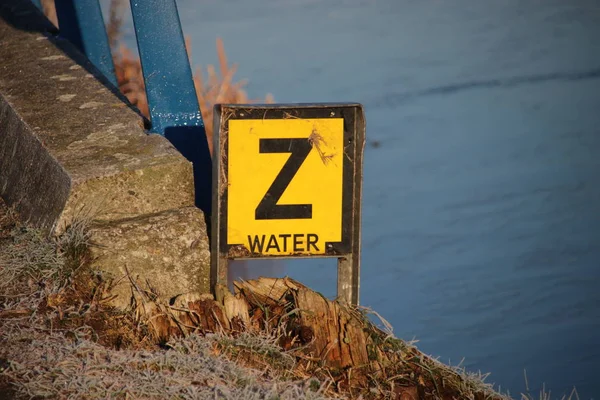 Yellow warning sign with letter \'Z\' to warn that a water pipe have sunken on the bottom of the canal.