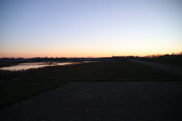 日落反射在荷兰鹿特丹附近的泽文胡祖的 Rottemeren Rote 河的水面上 — 图库照片